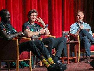 Jack Riewoldt emceeing a discussion panel with Tasmania JackJumpers. He wears a blue shirt.