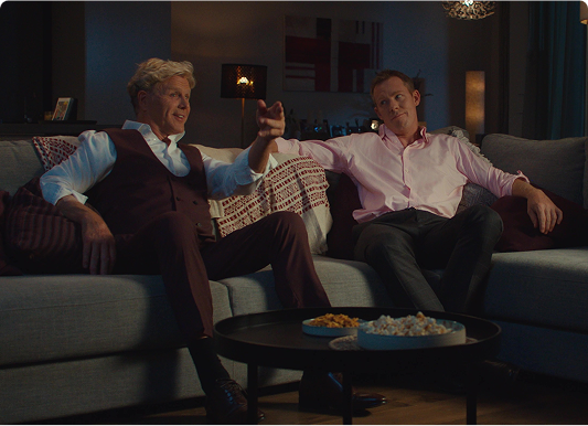 Jack Riewoldt and Dermott Brereton in a TV ad, sitting on a couch and sharing tacos.
