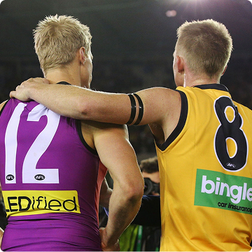 Jack Riewoldt and Nick Riewoldt with arms around each other. Nick in a purple number 12 guernsey, Jack in a yellow number 8 guernsey. Image Credit: St Kilda Football Club